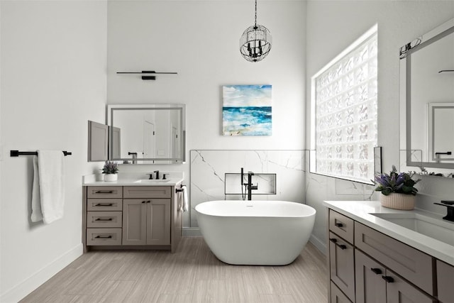 291 Torrington Dr, Austin, TX 78737 - bathroom featuring two vanities, a freestanding tub, and a chandelier