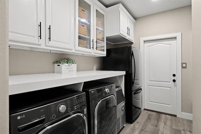 291 Torrington Dr, Austin, TX 78737 - laundry area featuring separate washer and dryer, light wood-style floors, and cabinet space