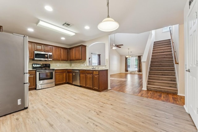 9004 Postvine Dr, Austin, TX 78724 - kitchen featuring stainless steel appliances, light wood-style floors, tasteful backsplash, brown cabinetry, and recessed lighting