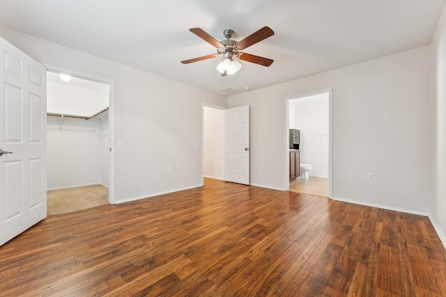 9004 Postvine Dr, Austin, TX 78724 - unfurnished bedroom featuring wood-type flooring, a walk in closet, ensuite bath, a closet, and a ceiling fan
