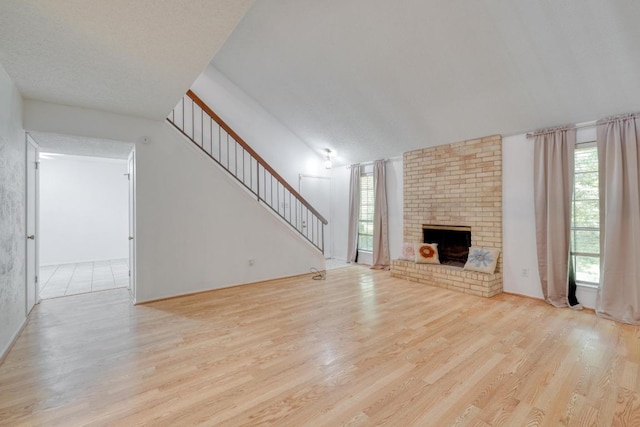 7400 Ophelia Dr, Austin, TX 78752 - unfurnished living room featuring wood finished floors, stairs, and a fireplace
