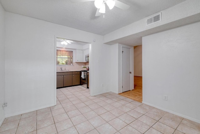 7400 Ophelia Dr, Austin, TX 78752 - unfurnished living room with ceiling fan and a textured ceiling