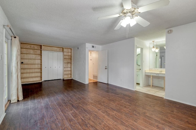 7400 Ophelia Dr, Austin, TX 78752 - unfurnished bedroom with wood finished floors, a textured ceiling, a closet, and ensuite bathroom