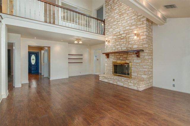 2981 Vivroux Ranch Rd, Seguin, TX 78155 - unfurnished living room featuring wood finished floors, a fireplace, and a high ceiling