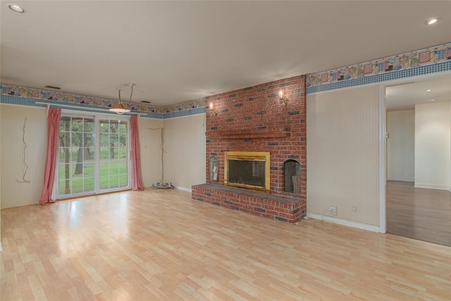 2981 Vivroux Ranch Rd, Seguin, TX 78155 - unfurnished living room featuring wood finished floors and a brick fireplace