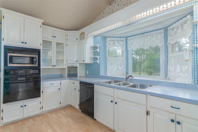 2981 Vivroux Ranch Rd, Seguin, TX 78155 - kitchen with black appliances, vaulted ceiling, white cabinets, light wood-style floors, and light countertops
