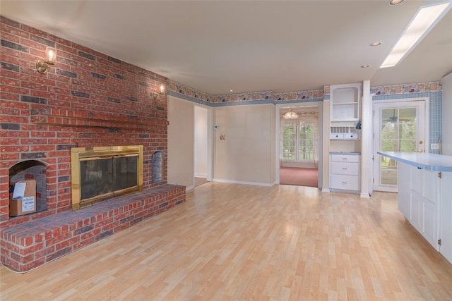 2981 Vivroux Ranch Rd, Seguin, TX 78155 - unfurnished living room featuring light wood-type flooring and a fireplace
