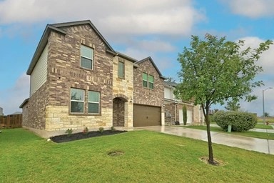17320 Calipatria Ln, Pflugerville, TX 78660 - view of front of property featuring stone siding, an attached garage, and driveway