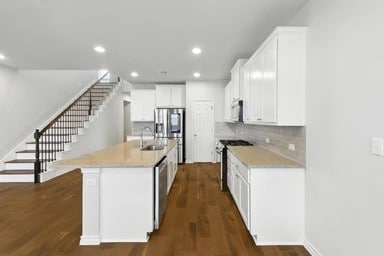 17320 Calipatria Ln, Pflugerville, TX 78660 - kitchen featuring stainless steel appliances, recessed lighting, light countertops, white cabinetry, and dark wood-type flooring