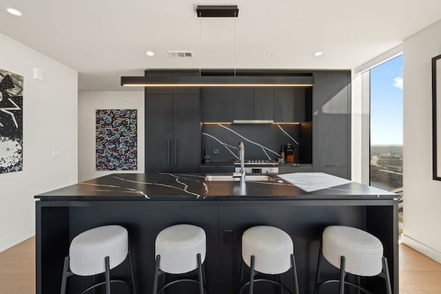 44 E Ave Unit 3801, Austin, TX 78701 - bar area with light wood-style floors, recessed lighting, hanging light fixtures, and backsplash