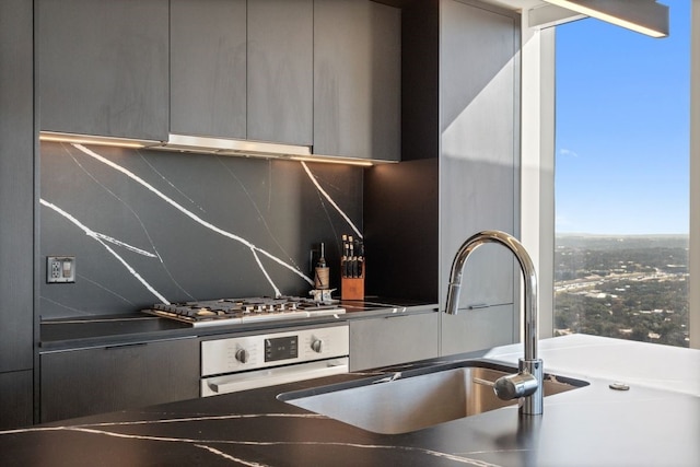 44 E Ave Unit 3801, Austin, TX 78701 - kitchen featuring oven, modern cabinets, under cabinet range hood, decorative backsplash, and gray cabinets