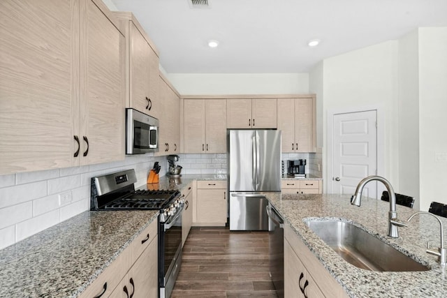180 Yellowstone Dr, Kyle, TX 78640 - kitchen featuring appliances with stainless steel finishes, light brown cabinets, backsplash, light stone countertops, and dark wood-style flooring