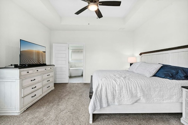 180 Yellowstone Dr, Kyle, TX 78640 - bedroom featuring a raised ceiling, light colored carpet, a ceiling fan, and ensuite bathroom