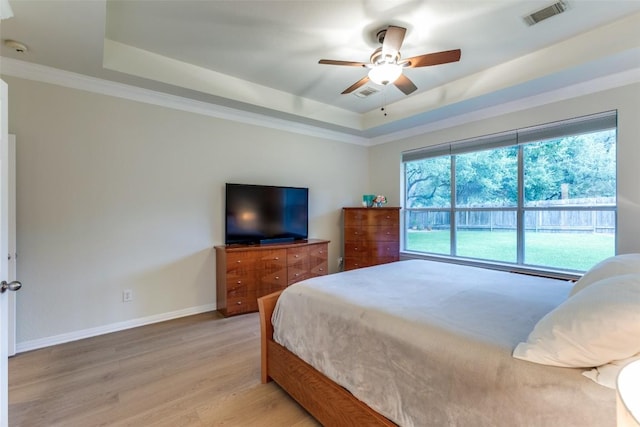 12816 Texas Sage Ct, Austin, TX 78732 - bedroom featuring a raised ceiling, light wood-style flooring, crown molding, and a ceiling fan