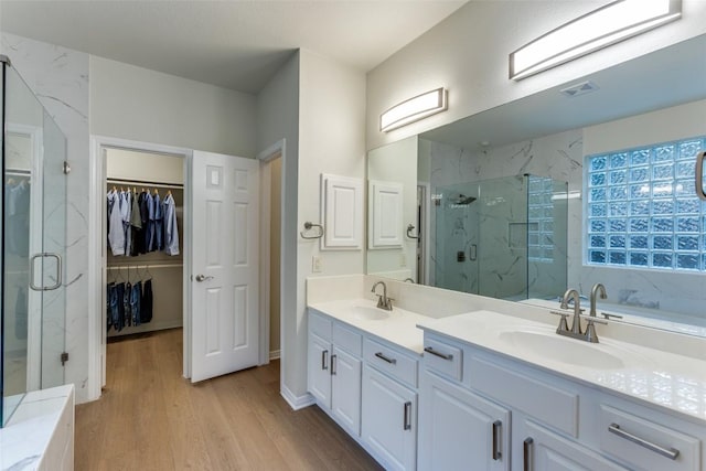 12816 Texas Sage Ct, Austin, TX 78732 - full bath featuring a marble finish shower, double vanity, wood finished floors, and a spacious closet