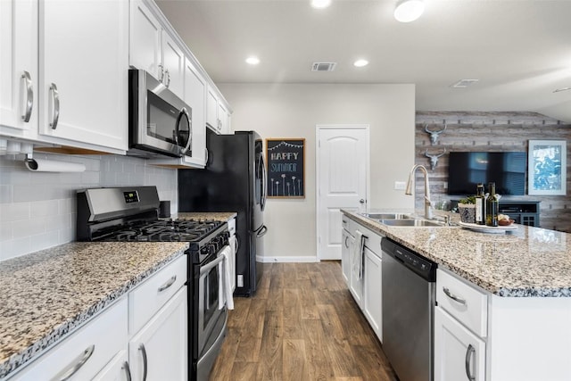 118 Craft St, Hutto, TX 78634 - kitchen featuring stainless steel appliances, dark wood-style flooring, white cabinets, a kitchen island with sink, and light stone countertops