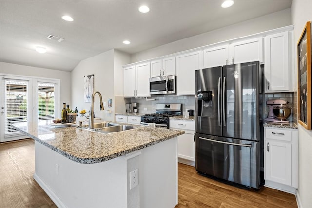 118 Craft St, Hutto, TX 78634 - kitchen featuring appliances with stainless steel finishes, wood finished floors, decorative backsplash, white cabinets, and recessed lighting