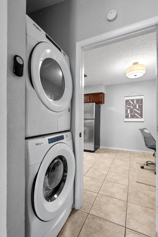 8406 Copano Dr, Austin, TX 78749 - laundry room featuring stacked washer and clothes dryer and light tile patterned floors