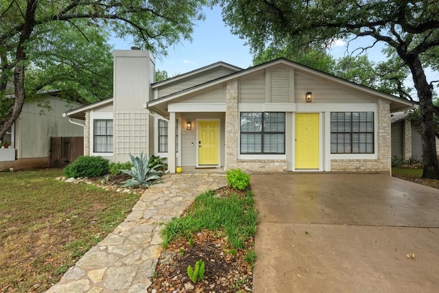 8406 Copano Dr, Austin, TX 78749 - mid-century home with a chimney, stone siding, and concrete driveway