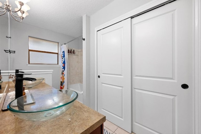 8406 Copano Dr, Austin, TX 78749 - full bathroom with a textured ceiling, vanity, tile patterned flooring, shower / bathtub combination with curtain, and a chandelier