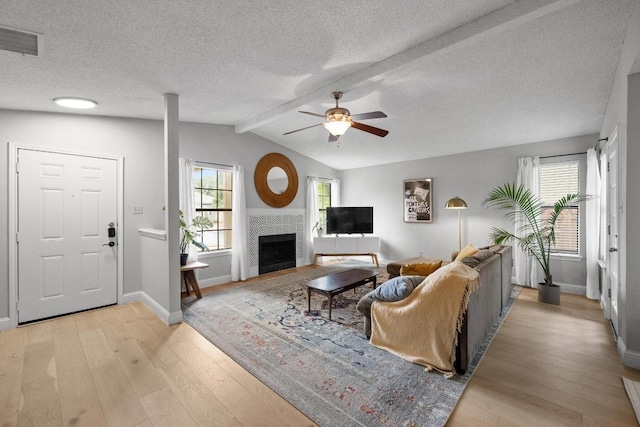 8406 Copano Dr, Austin, TX 78749 - living area featuring light wood-type flooring, ceiling fan, a fireplace, and a textured ceiling