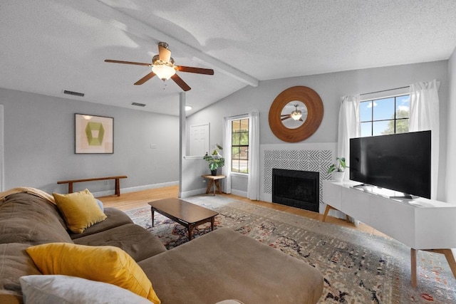 8406 Copano Dr, Austin, TX 78749 - living area with a ceiling fan, wood finished floors, a tiled fireplace, and a textured ceiling