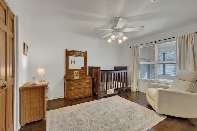 830 Palomino Ln, San Marcos, TX 78666 - bedroom with dark wood-style flooring, a ceiling fan, and a crib