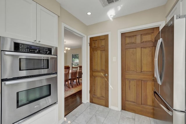 830 Palomino Ln, San Marcos, TX 78666 - kitchen with stainless steel appliances, white cabinets, and a chandelier