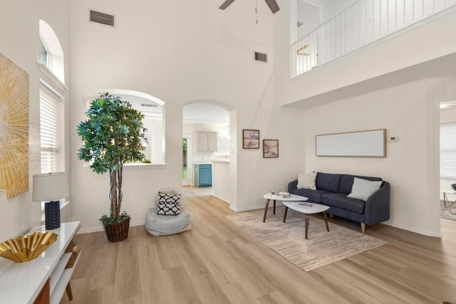 1449 Sir Thopas Trl, Austin, TX 78748 - living room with a towering ceiling, ceiling fan, wood finished floors, and arched walkways