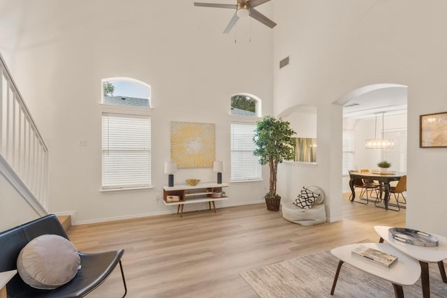 1449 Sir Thopas Trl, Austin, TX 78748 - living room featuring a high ceiling, arched walkways, a ceiling fan, wood finished floors, and plenty of natural light