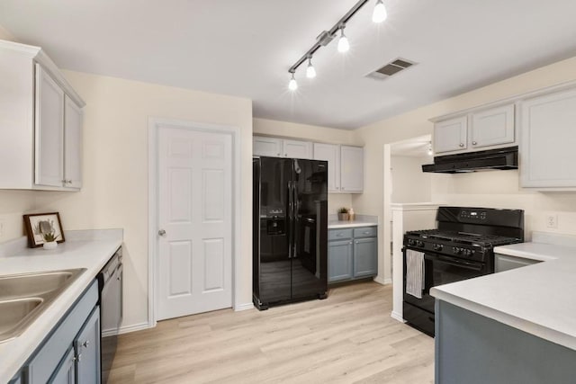 1449 Sir Thopas Trl, Austin, TX 78748 - kitchen with black appliances, under cabinet range hood, gray cabinetry, and light wood-style floors