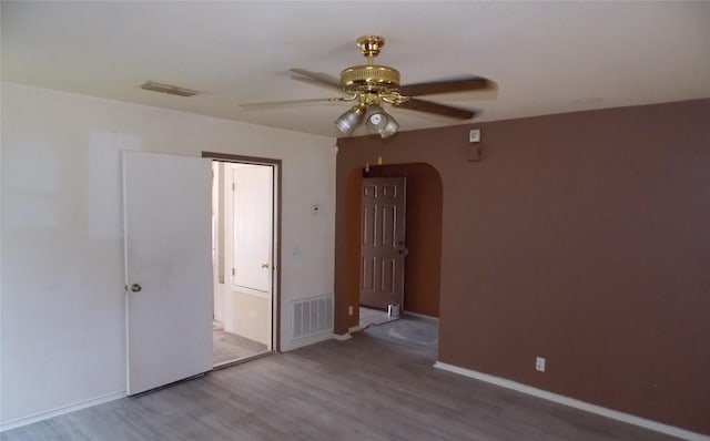 15110 Chamberlain Ct, Austin, TX 78724 - empty room with ceiling fan, arched walkways, and wood finished floors