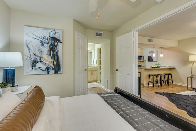7685 Northcross Dr Unit 907, Austin, TX 78757 - bedroom with wood finished floors and ensuite bathroom