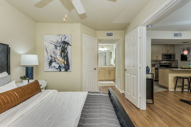 7685 Northcross Dr Unit 907, Austin, TX 78757 - bedroom with wood finished floors, ceiling fan, and ensuite bathroom