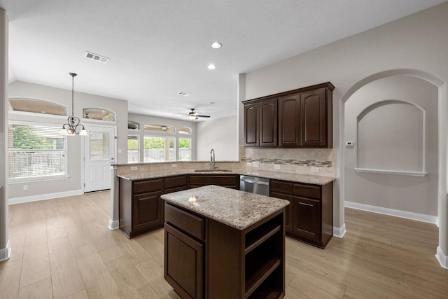 136 Firefall Ln, Austin, TX 78737 - kitchen featuring stainless steel dishwasher, dark brown cabinetry, backsplash, light wood finished floors, and recessed lighting