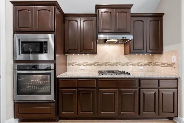 136 Firefall Ln, Austin, TX 78737 - kitchen featuring stainless steel appliances, dark brown cabinets, under cabinet range hood, and decorative backsplash