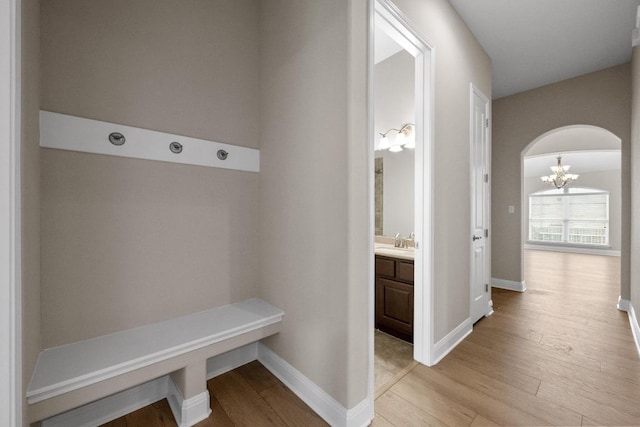 136 Firefall Ln, Austin, TX 78737 - mudroom with a chandelier, light wood finished floors, and arched walkways