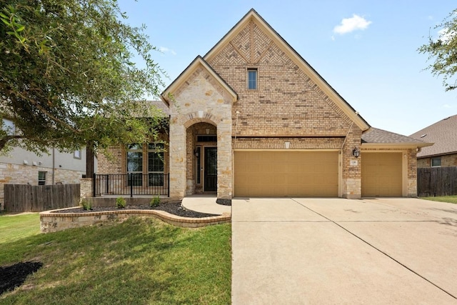 136 Firefall Ln, Austin, TX 78737 - french country home with brick siding, concrete driveway, and stone siding