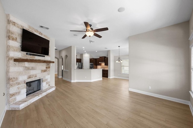 136 Firefall Ln, Austin, TX 78737 - unfurnished living room with a ceiling fan, a fireplace, and light wood-style flooring