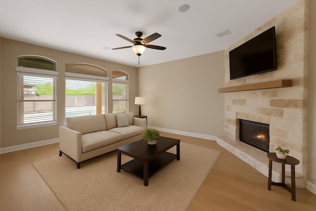 136 Firefall Ln, Austin, TX 78737 - living area featuring a glass covered fireplace, a ceiling fan, and wood finished floors