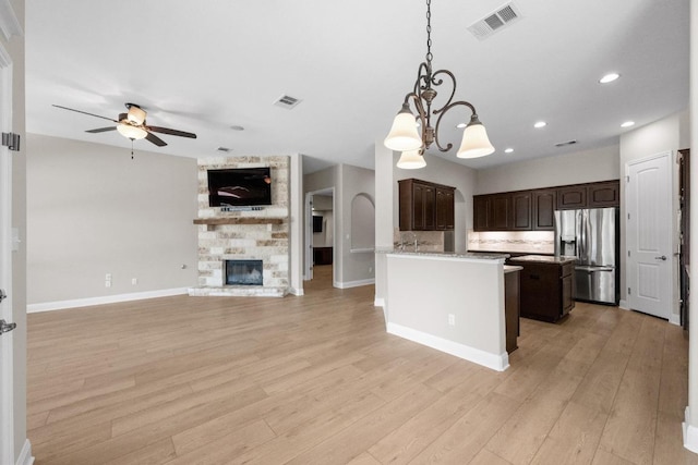 136 Firefall Ln, Austin, TX 78737 - kitchen with stainless steel fridge with ice dispenser, open floor plan, ceiling fan, dark brown cabinets, and a chandelier