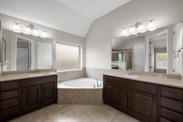 136 Firefall Ln, Austin, TX 78737 - full bathroom with a shower stall, vaulted ceiling, a garden tub, two vanities, and tile patterned flooring