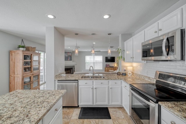 1511 Rhapsody Ridge Dr, Cedar Park, TX 78613 - kitchen with stainless steel appliances, tasteful backsplash, white cabinetry, light stone countertops, and recessed lighting