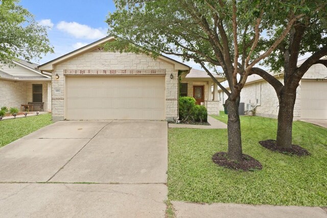 11012 Short Springs Dr, Austin, TX 78754 - ranch-style home with stone siding, a garage, a front yard, and concrete driveway