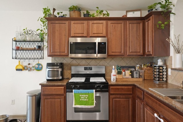 11012 Short Springs Dr, Austin, TX 78754 - kitchen featuring appliances with stainless steel finishes, backsplash, and brown cabinets