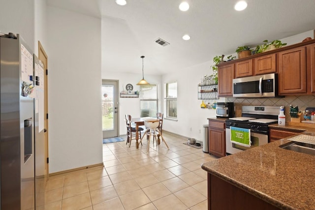 11012 Short Springs Dr, Austin, TX 78754 - kitchen with stainless steel appliances, brown cabinets, backsplash, dark countertops, and recessed lighting