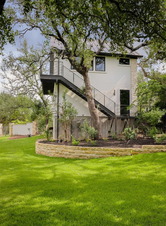 4100 Mcbrine Pl, Austin, TX 78746 - back of house featuring a yard, stucco siding, and stairs