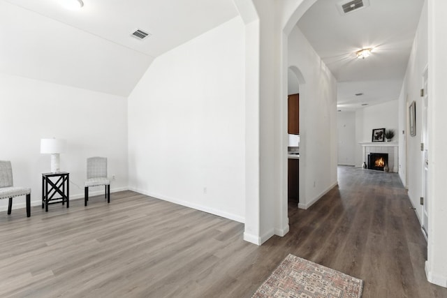 107 Chandler View Trl, Round Rock, TX 78665 - unfurnished room featuring wood finished floors, arched walkways, a fireplace, and vaulted ceiling