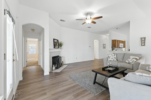 107 Chandler View Trl, Round Rock, TX 78665 - living area with arched walkways, ceiling fan, light wood-type flooring, and a tile fireplace
