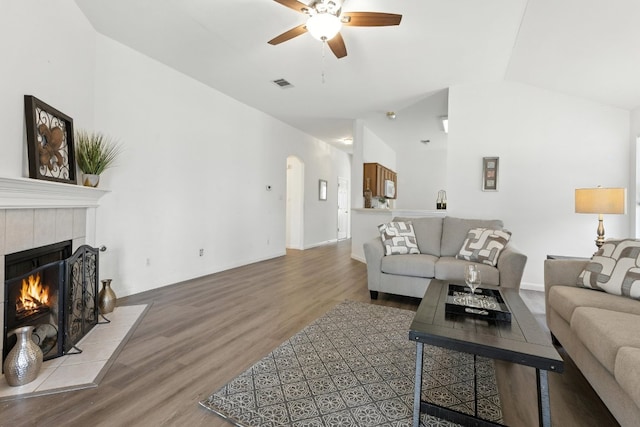 107 Chandler View Trl, Round Rock, TX 78665 - living room featuring ceiling fan, a tile fireplace, wood finished floors, vaulted ceiling, and arched walkways